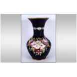 A Victorian Pottery Decorated Vase with a black body decorated with pink and various coloured roses.