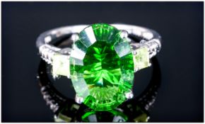 Helenite and Peridot Ring, an oval cut 4.5ct helenite, an unusual transparent green stone formed
