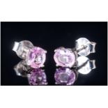 Pink Sapphire Stud Earrings, two solitaire oval cut pink sapphires totalling .75ct, set in rhodium