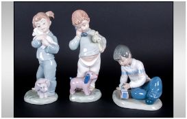 Three Nao by Lladro Porcelain Figures comprising two boys and a girl with soft toys and train,