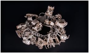 A Vintage And Quality Silver Charm Bracelet loaded with 30 charms. All hallmarked. 154.3 grams.