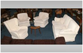 Four Piece Lounge Suite in cream fabric comprising three seater sofa and three single chairs.