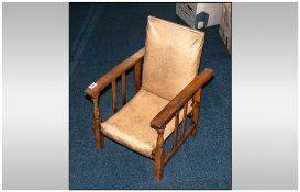 Small Arts & Crafts Childs Stained Beech Easy Armchair with turned spindles to the front. The