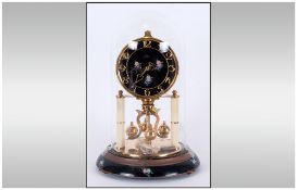 German 300 Day Anniversary Clock By Kein with a painted black floral dial & brass works under a