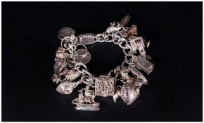 A Vintage And Good Quality Silver Charm Bracelet loaded with 20 charm, All Hallmarked. 101.11 grams