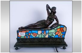 Modern Lamp In The Art Deco Style Of A Reclining Girl On A Leaded Glass Couch, acting as a lamp.