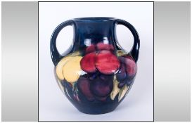 Moorcroft Two Handled Vase ' Wisteria Plums ' Design on Blue Ground. c.1920's. Height 5 Inches.