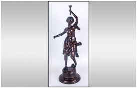 A Bronzed Figurine of a Young Woman Holding a Torch In a Standing Position, Raised on a Circular