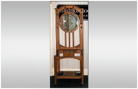 Art Nouveau Oak Hallstand With A Round Central Mirror supported on three slats, drawer to the centre