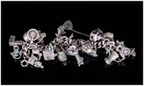 A Vintage and Heavy Silver Curb Bracelet, Loaded with 28 Silver Charms of Various Subjects and