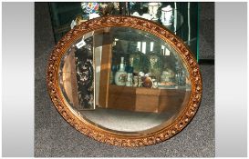 Oval Gilt Framed Mirror With A Bevelled Edge the frame in the Rococo style. 27x24''