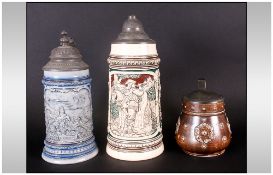 Three German Antique Stoneware Steins With Pewter Tops, one depicting a man blowing a hunting