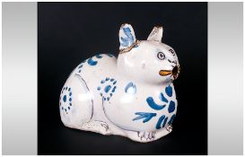 Rare Antique Delftware Cat Of Unusual Reclining Form decorated in blue hues and yellow highlights to