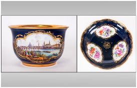 Meissen Cabinet Cup and Saucer, showing a hand painted polychrome scene of Dresden in a quatrefoil