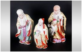 Three Chinese Famile Rose Porcelain Decorated Figures Of Three Wise Man Or Sages, one reading a