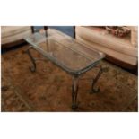 Continental Wrought Iron Coffee Table In The French Style with shaped legs & glass top.