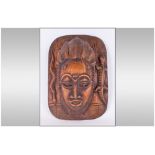 An African Carved Ornate Wall Mask depicting a woman with an elaborate hair style,.