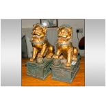 A Pair of Chinese Style Gilded Foo Dogs in the classical style. On a rectangular base.
