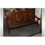 A Lancashire Oak Hall Bench with a four panelled Chamfered shaped back. On O G shaped arms.