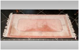 Small Rectangular Wool Rug, predominantly pale pink in colour with beige border. 140x70cm