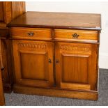 An Oak Two Drawer Cupboard with scratch carving to the dorr and brass drop handles. 40 inches high