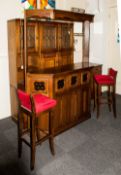 A Priory Type Oak Bar with a shaped top with glass panels below and further linen fold panels.