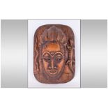 An African Carved Ornate Wall Mask depicting a woman with an elaborate hair style,. With openings to