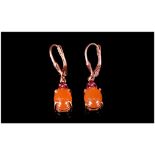 Pair of Peach Moonstone and Rhodolite Garnet Drop Earrings, a single peach moonstone cabochon, set