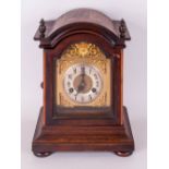 Brass Arch dial German Mantle Clock, by Junghams. In a stained walnut case with pressed brass relief