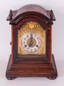 Brass Arch dial German Mantle Clock, by Junghams. In a stained walnut case with pressed brass relief