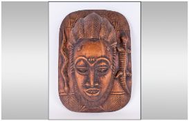 An African Carved Ornate Wall Mask depicting a woman with an elaborate hair style,. With openings to