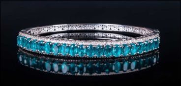 Blue/Green Quartz Bangle, oval cut blue/green quartz set vertically in a millegrain frame across the