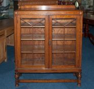 A 1930's Double Glazed Door Oak Display Cabinet On Turned Legs with a cross stretcher. 41'' in