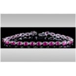 Ruby Tennis Bracelet, 18cts of rubies with a deep fuchsia pink undertone, oval cut and set in silver
