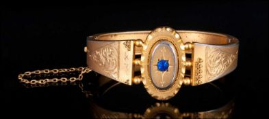 Early Victorian Gilt Metal Hinged Bangle with sapphire set centre & chased decoration to shoulders