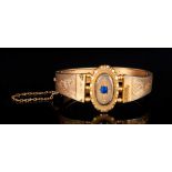 Early Victorian Gilt Metal Hinged Bangle with sapphire set centre & chased decoration to shoulders