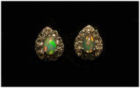 Opal and White Topaz Pair of Stud Earrings, each earring comprising a pear cut opal cabochon of .