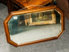 1920's Oak Framed Mahogany Mirror, with bevelled glass and measuring 29 by 18 inches.