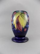 William Moorcroft Signed Vase ' Leaves and Berries ' on Blue Ground. c.1930's. Stands 6 Inches High.