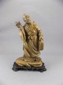 Japanese Late 19thC Soap Stone Figure of a Japanese male figure dressed in a robe carrying a water