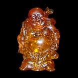 琥珀雕布袋和尚立像 An Amber Carving of Budai Carrying His Bag. Height: 3⅜ in (8.6 cm) 
Weight: 154 g.