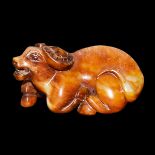 紅玉精雕臥牛賞件 A Reddish Russet Jade Carving of a Recumbent Buffalo. Length: 4¼ in (10.8 cm) Weight: 468