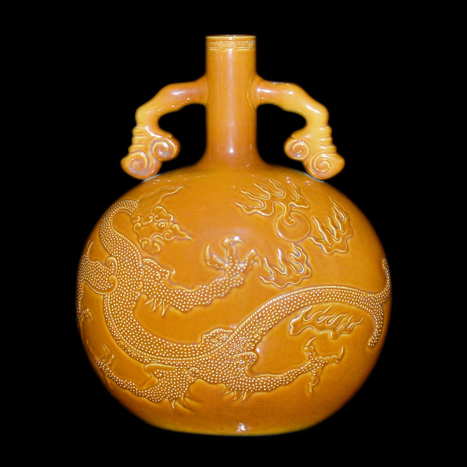 醬釉浮雕龍紋如意綬帶耳抱月瓶 Amber-Glazed Moon Flask Carved with Dragons Chasing Flaming Pearls with Ruyi Loop