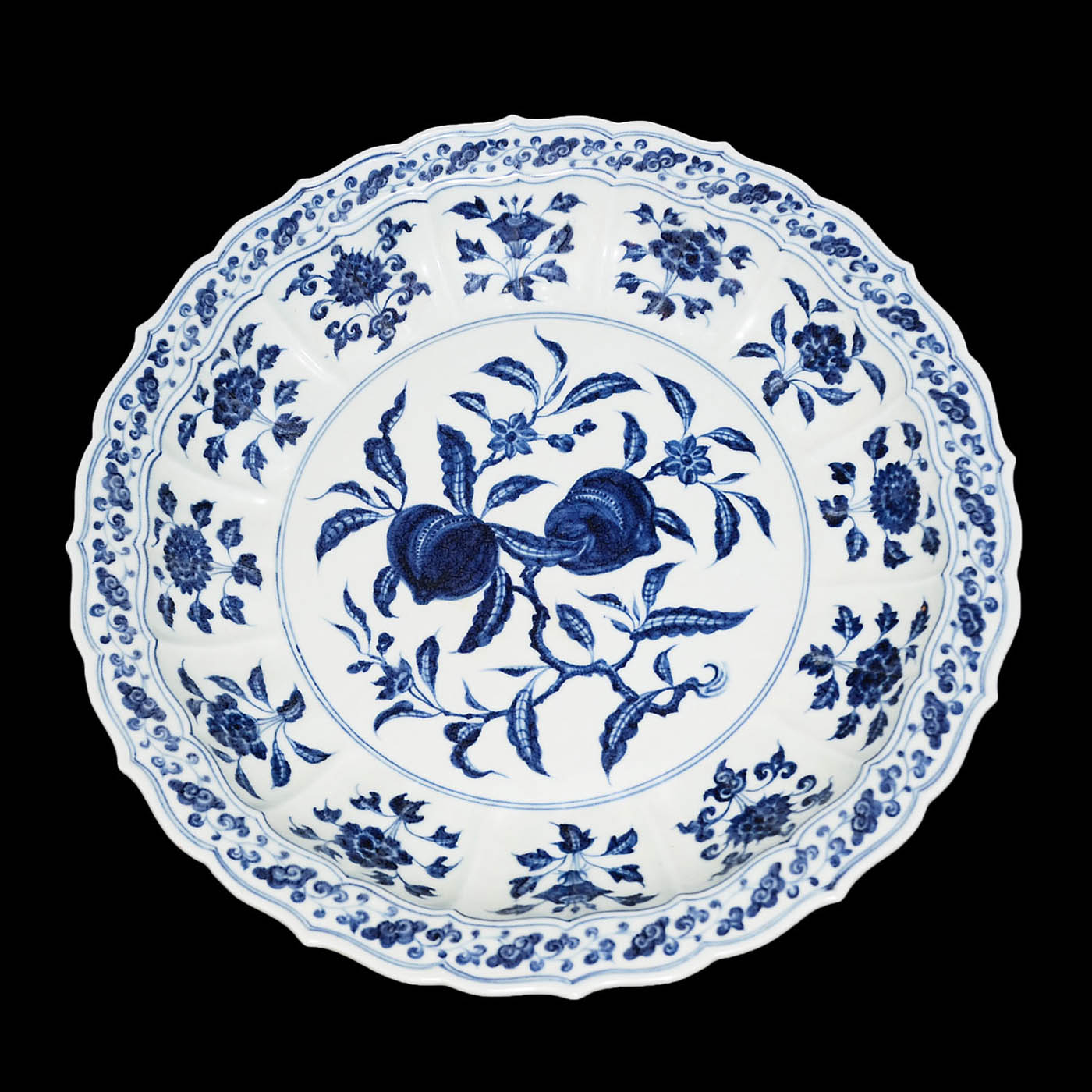 青花花卉花瓣折沿棱口大盤 A Large Blue and White Floral Charger The central medallion with fruit blooms encircled