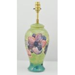 Moorcroft lamp base, with stylised flower decoration to a green ground, approximately 20cm.