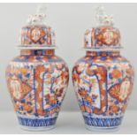 Pair of Japanese Imari bolster vases, with domed covers, surmounted by Kilians, circa 1875,