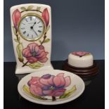 Moorcroft mantel clock, magnolia on an ivory coloured ground, 1994, 16cm and a magnolia paperweight