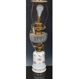 Porcelain and gilt metal mounted oil lamp, the base painted with floral sprigs,