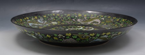 A Chinese black ground Famille Verte dished circular charger, bearing Kangxi six character mark,