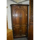 Georgian oak freestanding corner cupboard, henkle and cavetto cornice, two arched and fielded panel